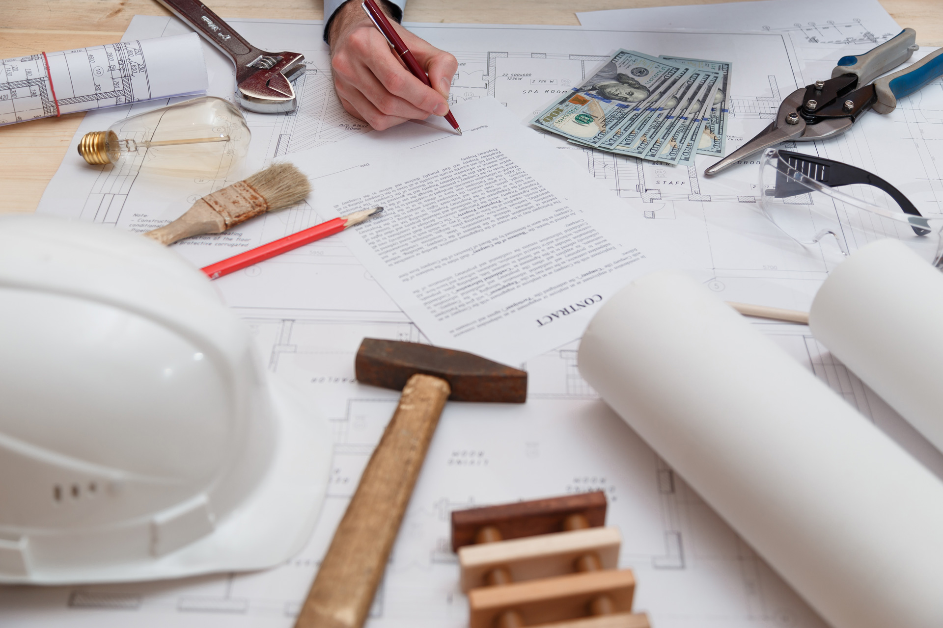 commercial contractor equipment on a table, with a hammer, hard hat, etc.