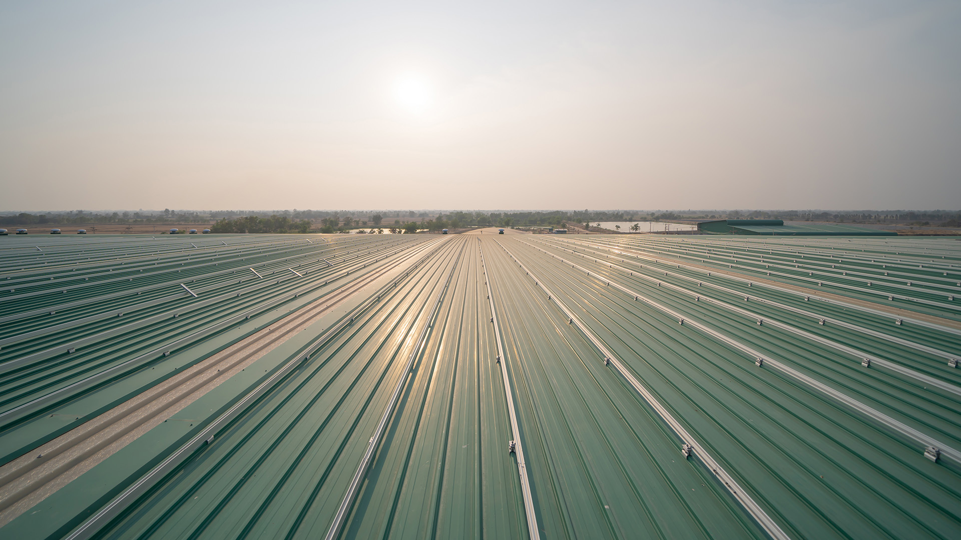 Metal sheet corrugated roof on rooftop of industry factory. Steel structure of station building